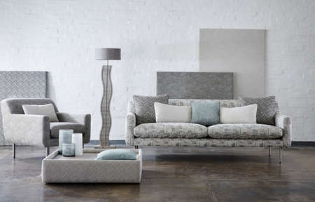 Shot of grey color armchair with pillow on hardwood floorの写真素材