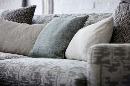 Shot of grey color armchair with pillow on hardwood floorの写真素材