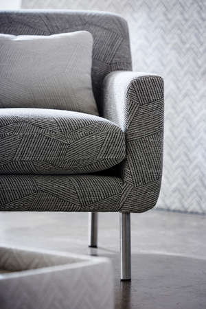 Shot of grey color armchair with pillow on hardwood floorの写真素材
