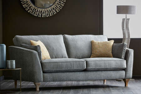 Shot of grey color armchair with pillow on hardwood floorの写真素材
