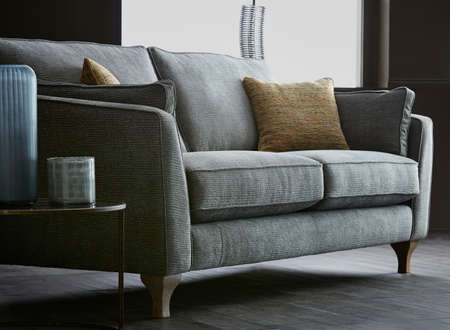 Shot of grey color armchair with pillow on hardwood floorの写真素材