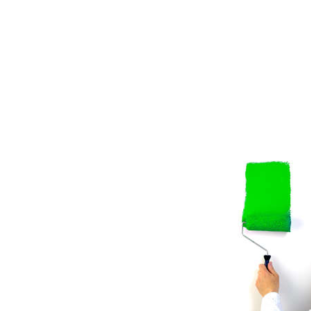 Shot of a hand with paintroller painting white wall greenの写真素材