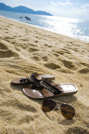 Female sandal and shades on the beachの写真素材