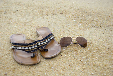 Female sandal and shades on the beachの写真素材