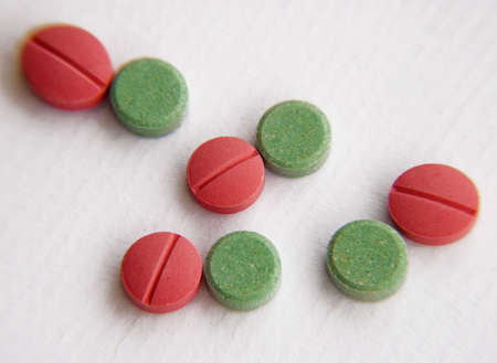 Green and red tablets on white backgroundの写真素材