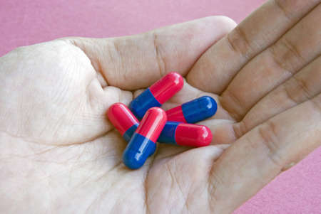 Hand filled with red-blue pills