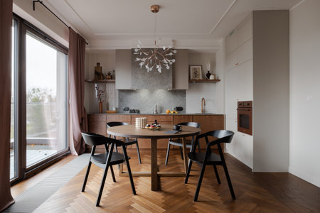 Dining area with table, chairs, and kitchen in the backgroundの写真素材