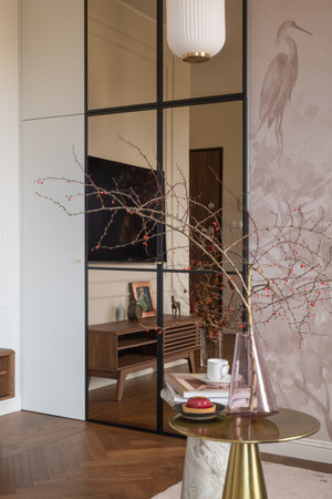 a living room with a sliding glass door and a table with a vase of flowers on itの写真素材