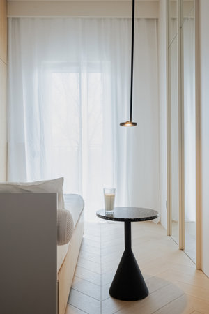 A wood table stands in the center of the room near a bedの写真素材