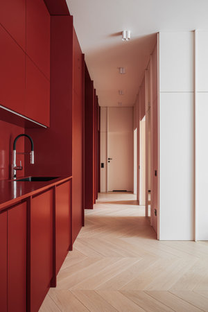 Hallway kitchen with red cabinet and a brown sink fixtureの写真素材