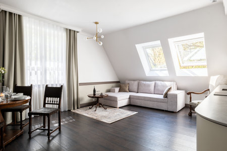 Living room with couch, chairs, table, and window fixture in a houseの写真素材