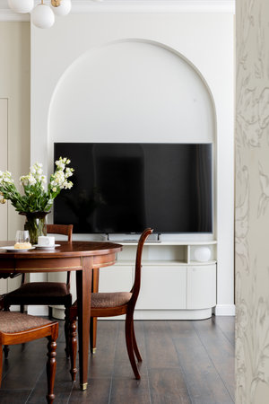 A dining room with a wooden table, chairs, and a flat screen TVの写真素材