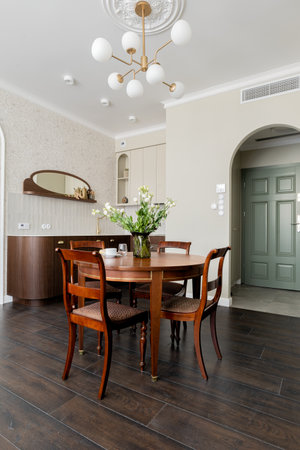 Dining room with table, chairs, chandelier in a hardwoodfloored buildingの写真素材