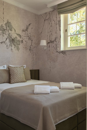a bedroom with a large bed and a windowの写真素材