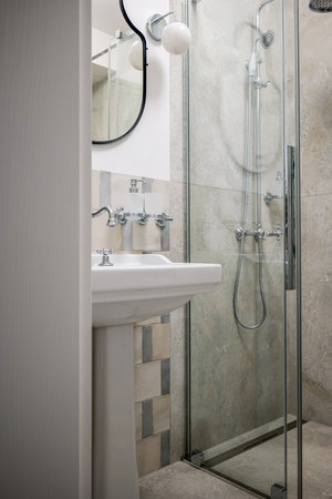 A bathroom with plumbing fixtures like a sink, tap, and walkin showerの写真素材