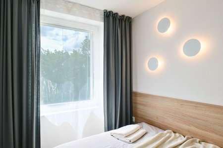 A Stylish Bedroom Featuring Modern Decor Elements and Elegant Lighting Fixtures for a Cozy Ambianceの写真素材