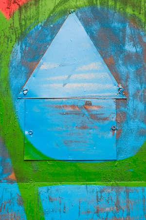 blank old warning notice shaped as house. brightly painted in blue and green colors. abstract background. metal texture. nails. notice. announce. warning signの写真素材