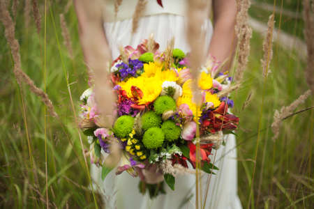 wedding flowers. close-up. beautiful young bride with wedding bouquet in hands. close up woman holding flowers. vertical photo. wedding dayの写真素材