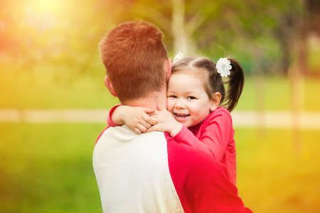 Beautiful girl of 3 yers hugging her daddy with love.の写真素材