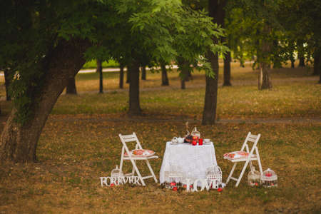 Beautiful photobooth in autumn wood. Decorated chairs and table. Image toned and stylized in retro style. Image toned and stylized in retro style.の写真素材