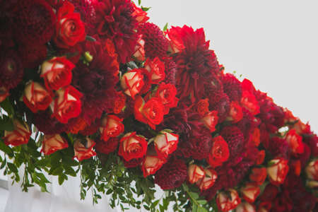 Beautiful floral decoration for outside wedding ceremony made of red flowers. Isolated on white. Wedding settings. Horizontal image toned in retro style.の写真素材