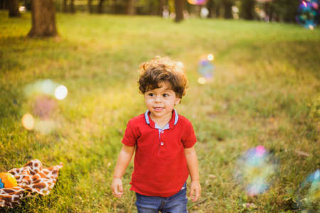 Little boy playing in the park with bubbles