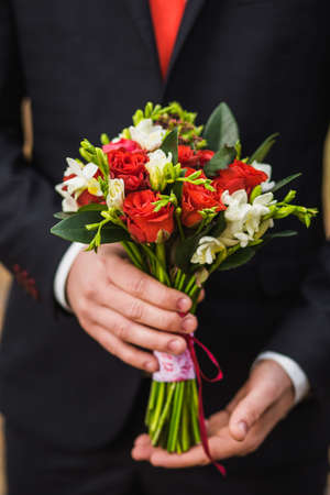 wedding bouquet in hands of the groom, man's fashionの写真素材