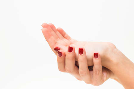 Young girl with beautiful red manicure holding hand as if showing something virtual and invisible on...