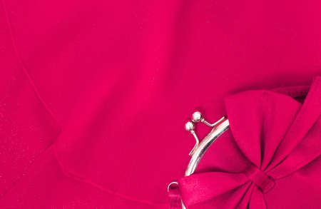Beautiful small red female clutch bag on red evening dress background. Close up of accessory and clothes perfectly matching to each other. Flat lay horizontal color photo.の写真素材