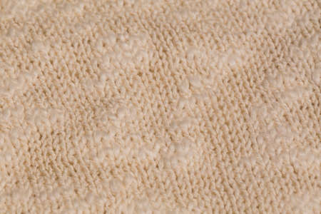 Macro color image of beige knitted texture.