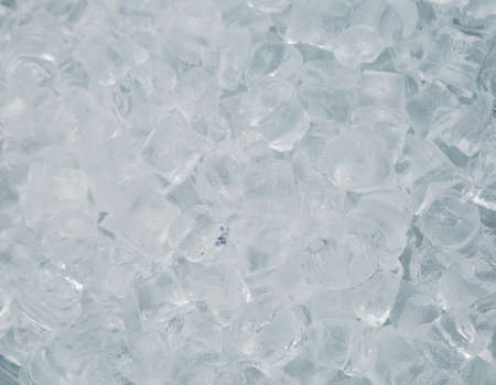 Top view of many transparent cubes of ice ready to use in drinks and cocktails. Icy background.