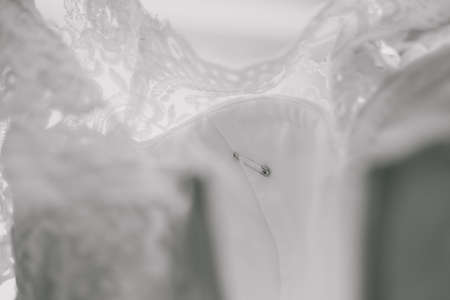 Safety pin on wedding dress. Horizontal color photography.の写真素材