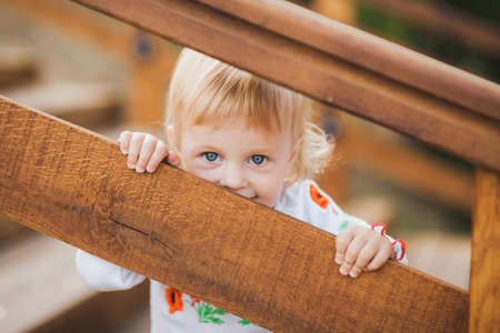 1 year old little caucasian girl palaing hide and seek game outdoors on sunny warm summer day.の写真素材