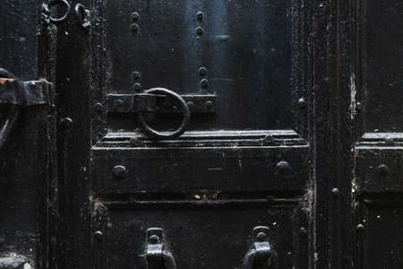 Closeup view of details of old black door. Horizontal color photography.