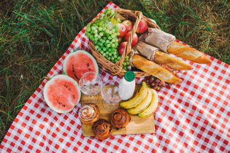 Healthy food for picnic outside. View from above of fresh buns, bread, yogurt, bananas, watermelon, green grape and red apples. Horizontal color image.の写真素材