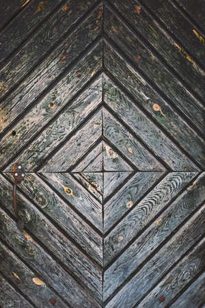 Closeup surface of old vintage wooden door with rusty handle. Vertical color photography.の写真素材