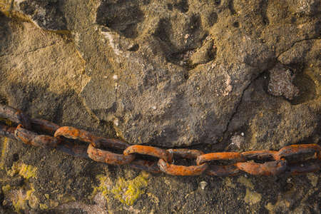 Old rusty chain underwater on sea bottom background. Horizontal color photo.