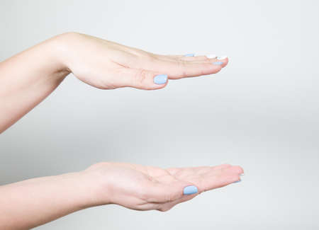 Closeup view of two female hands holding something invisible isolated on white background....