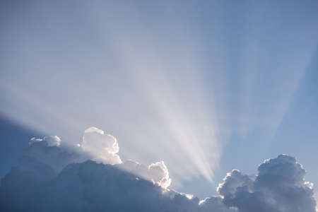 Beautiful cloudy blue sky and early morning soft sunlight behind fluffy white clouds. Beauty of nature. Horizontal color photography.の写真素材