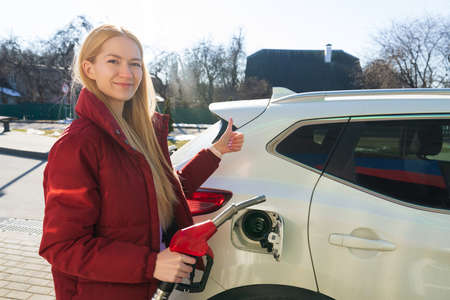 Beautiful young woman refueling her carの写真素材