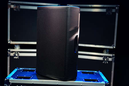 A sound speaker standing on boxes with concert equipment