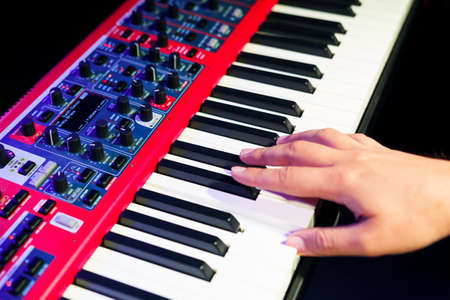Close-up of a pianist's hand on an electronic synthesizerの写真素材