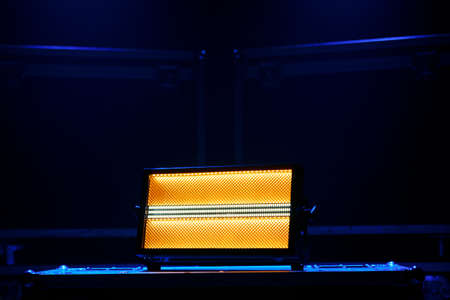The stage lighting device stands on boxes with equipment