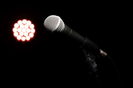 Classic microphone on the stand against the background of the concert lightの写真素材