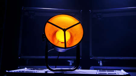 A light device that shines yellow stands on boxes with equipmentの写真素材