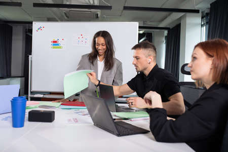 A young african american woman presents a project for colleagues in the officeの写真素材
