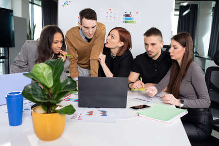 Five colleagues discuss work issues in the officeの写真素材