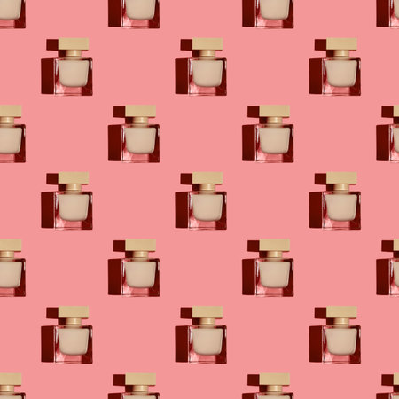 Top view of a pattern of bottles of women's perfume on a pink background