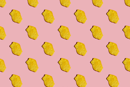 A pattern of potato chips on a pink background. top view