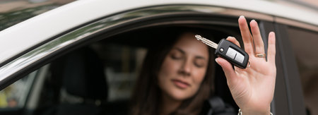 Close-up of the keys to the new car in the hands of a young woman. happy buyerの写真素材
